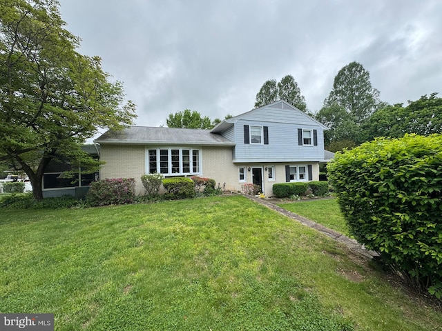 split level home with a front lawn and brick siding