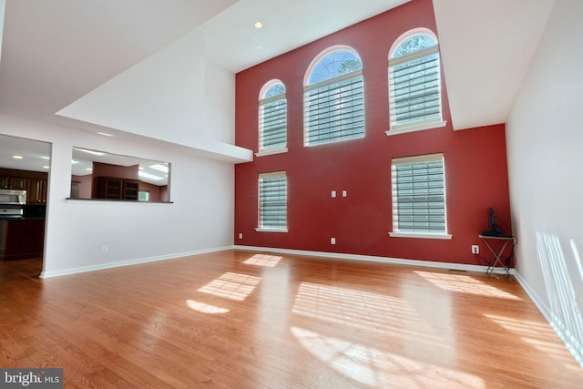 2 Raydan Way N, East, MD 21901 - unfurnished living room with light wood-style floors, a towering ceiling, and baseboards