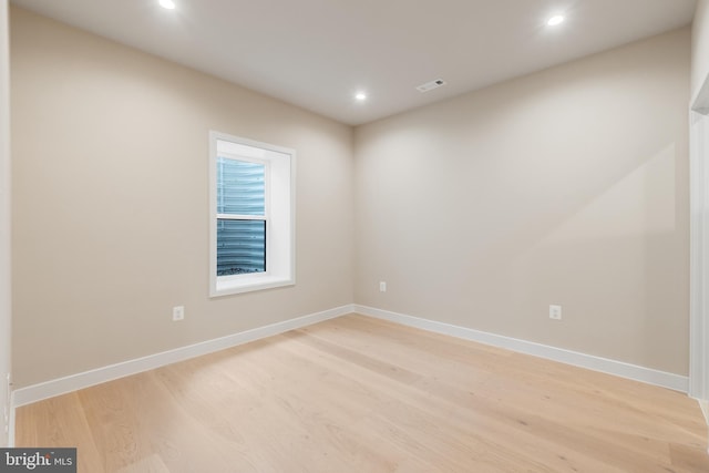 unfurnished room featuring baseboards, light wood-type flooring, visible vents, and recessed lighting