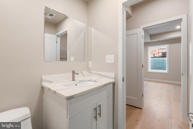 bathroom featuring vanity, toilet, visible vents, and wood finished floors