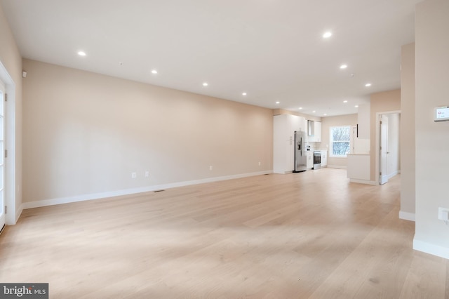 unfurnished living room with baseboards, light wood-style flooring, and recessed lighting