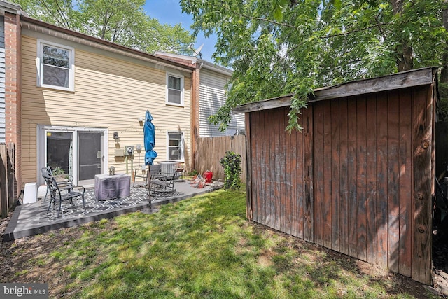 rear view of property with central AC, an outdoor structure, a storage shed, and a patio area