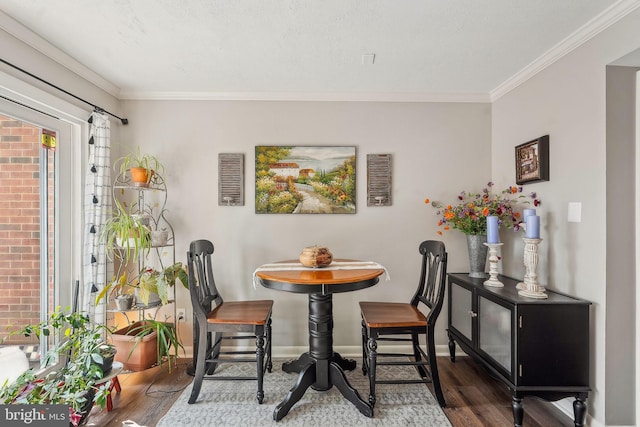 dining room featuring wood finished floors, ornamental molding, and baseboards