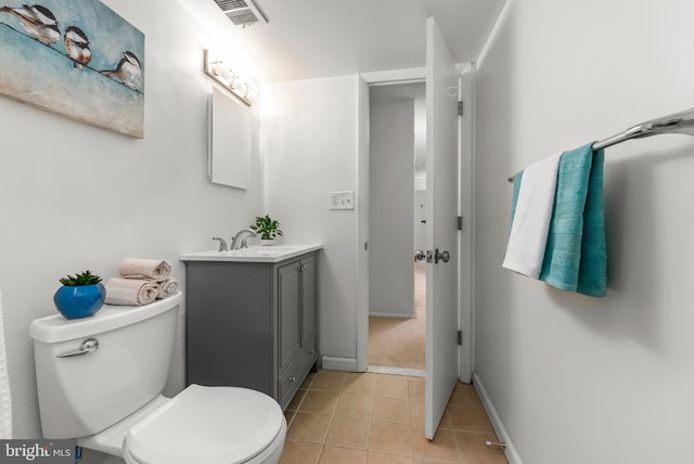 bathroom with toilet, vanity, tile patterned floors, and baseboards