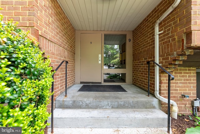 doorway to property with brick siding