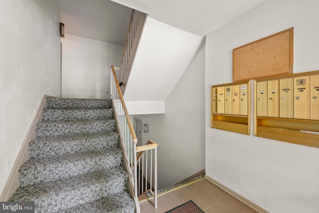 staircase with mail area and baseboards