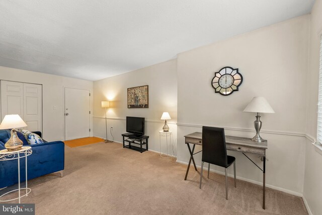 carpeted living area with baseboards