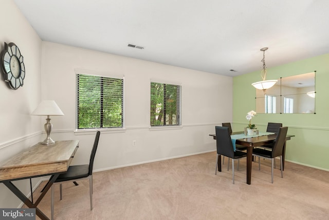 carpeted dining area with baseboards