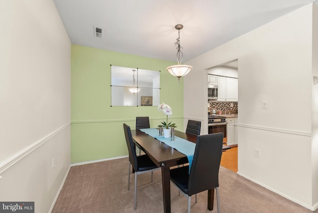 dining area with light colored carpet and baseboards