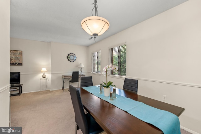 dining room featuring carpet flooring and baseboards