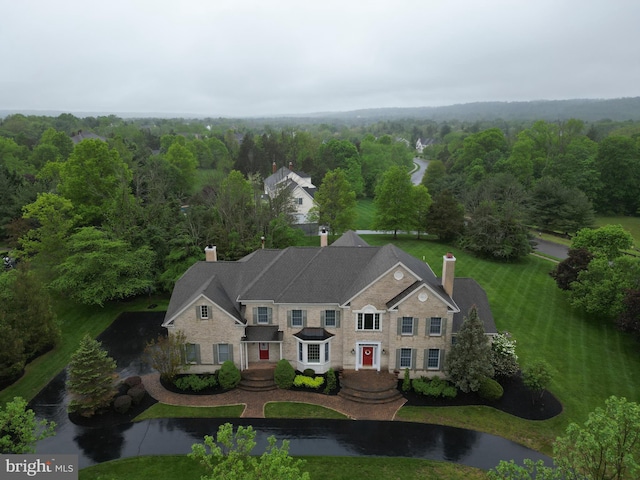 aerial view of property and surrounding area with a heavily wooded area