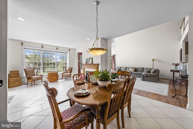 dining space featuring light tile patterned flooring, recessed lighting, and a fireplace