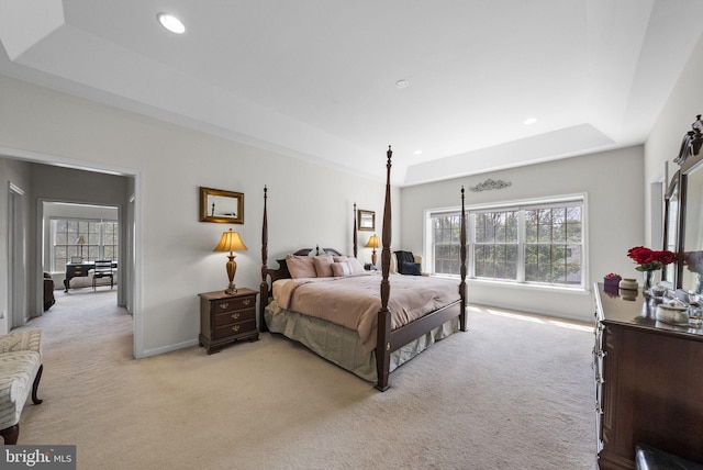 bedroom with a tray ceiling, light carpet, recessed lighting, and baseboards