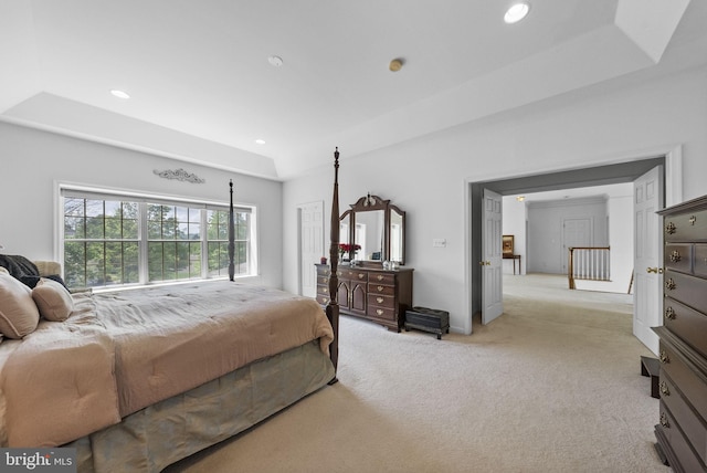 bedroom featuring light carpet, recessed lighting, and a tray ceiling