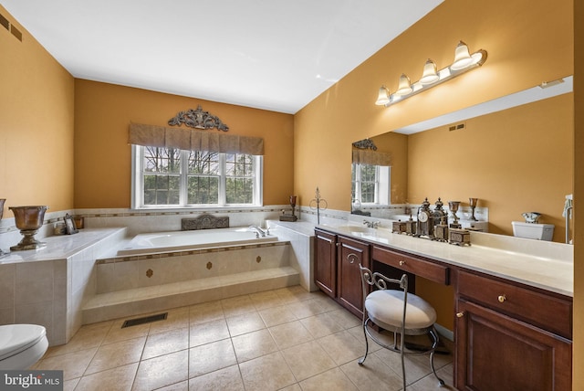 bathroom featuring plenty of natural light, a bath, vanity, and tile patterned flooring