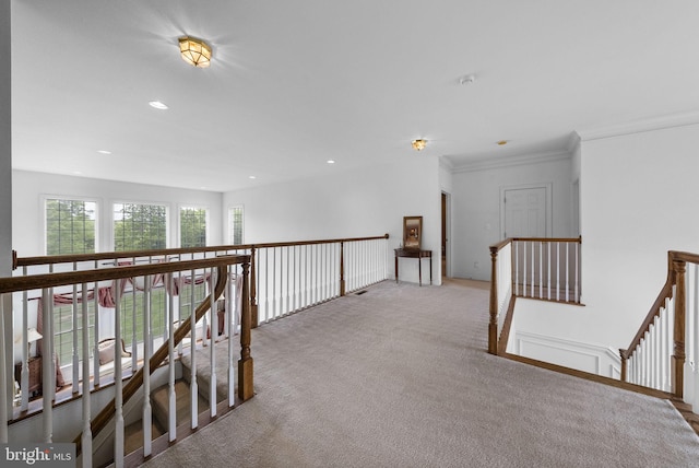 hallway with an upstairs landing, carpet, crown molding, and recessed lighting