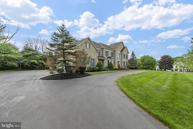 view of front of home featuring a front yard and stone siding