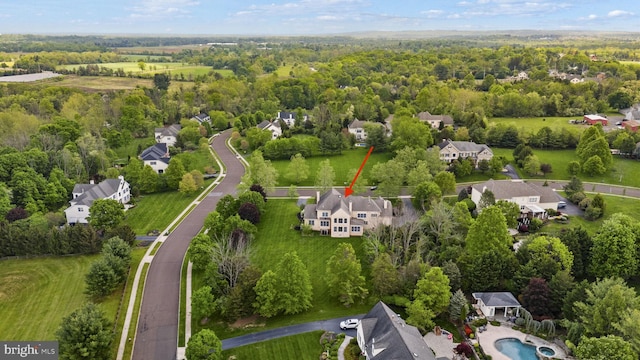 aerial view of property and surrounding area with nearby suburban area and a forest