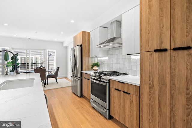 2811 S Hutchinson St, Philadelphia, PA 19148 - kitchen featuring stainless steel appliances, wall chimney exhaust hood, modern cabinets, light wood-type flooring, and recessed lighting