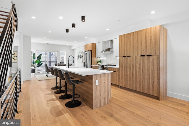 2811 S Hutchinson St, Philadelphia, PA 19148 - kitchen with modern cabinets, appliances with stainless steel finishes, wall chimney exhaust hood, an island with sink, and a sink