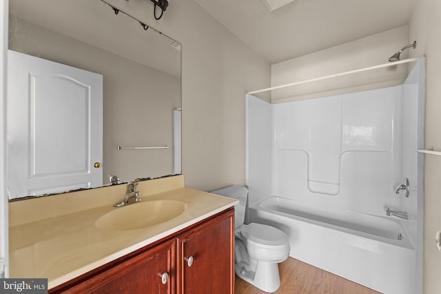 bathroom with wood finished floors, washtub / shower combination, vanity, and toilet