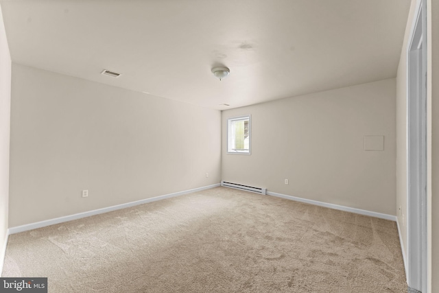 empty room with a baseboard heating unit, carpet, and baseboards