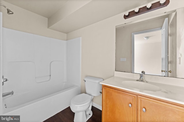 bathroom with toilet, wood finished floors, vanity,  shower combination, and baseboards