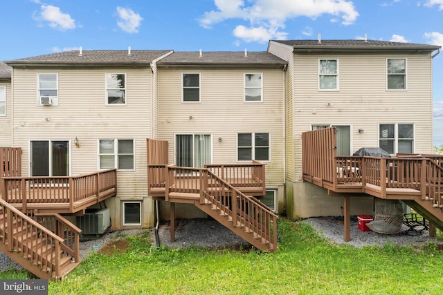 rear view of house with stairway and a wooden deck