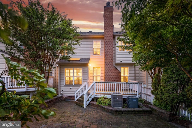 19599 Aspendale Sq, Ashburn, VA 20147 - back of house featuring a deck, central AC, a chimney, and a patio