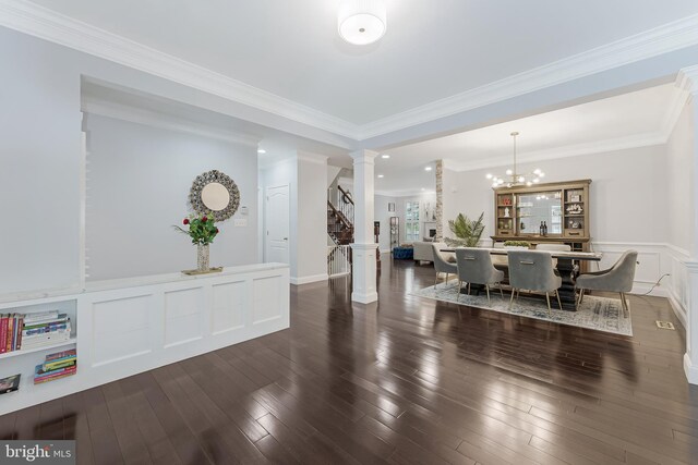 19599 Aspendale Sq, Ashburn, VA 20147 - entryway with ornate columns, stairway, wood finished floors, a wainscoted wall, and a chandelier