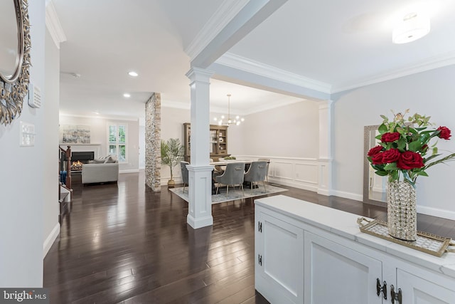 19599 Aspendale Sq, Ashburn, VA 20147 - hall with decorative columns, dark wood finished floors, ornamental molding, a wainscoted wall, and a chandelier