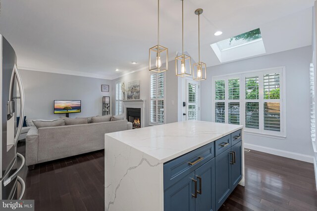 19599 Aspendale Sq, Ashburn, VA 20147 - kitchen featuring a skylight, dark wood-style floors, a lit fireplace, blue cabinets, and crown molding