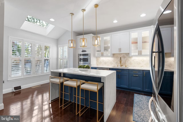 19599 Aspendale Sq, Ashburn, VA 20147 - kitchen featuring stainless steel appliances, blue cabinets, a sink, a skylight, and dark wood-style flooring