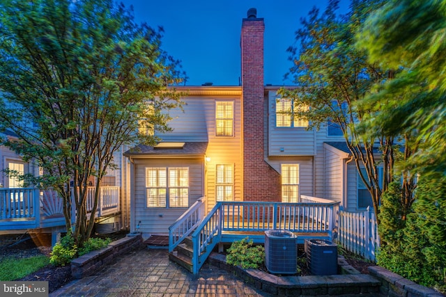 19599 Aspendale Sq, Ashburn, VA 20147 - view of front of home featuring a deck, a chimney, central AC, and a patio