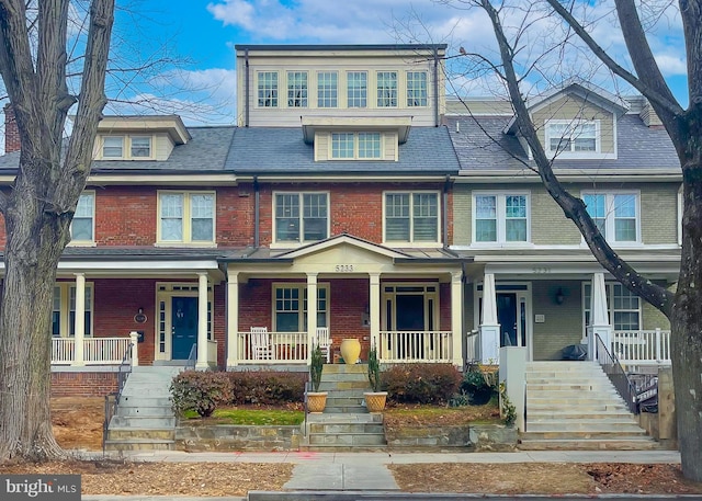 view of front of house featuring a porch, brick siding, and stairway