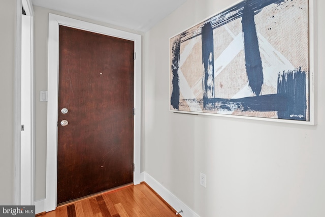 doorway to outside with baseboards and wood finished floors