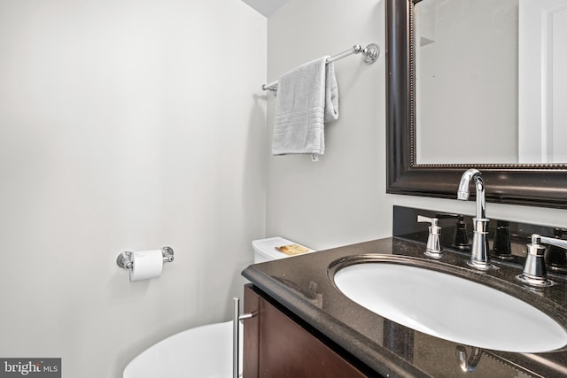 half bath featuring toilet and vanity