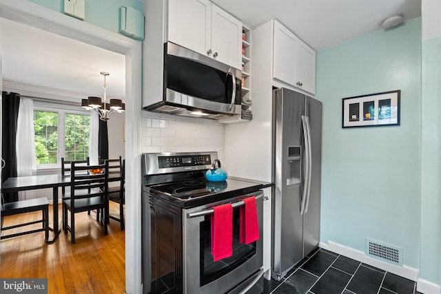 3210 Old Dominion Blvd, Alexandria, VA 22305 - kitchen featuring appliances with stainless steel finishes, white cabinetry, a chandelier, backsplash, and baseboards