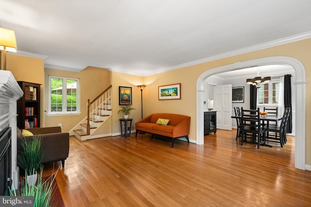 3210 Old Dominion Blvd, Alexandria, VA 22305 - living room featuring light wood finished floors, arched walkways, a fireplace with flush hearth, a chandelier, and ornamental molding