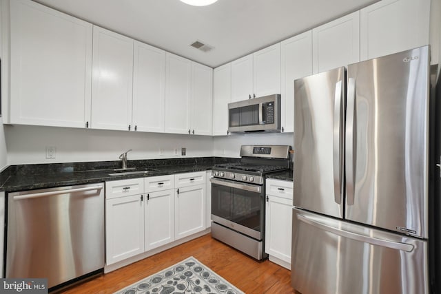 2120 Vermont Ave NW Unit 309, Washington, DC 20001 - kitchen featuring stainless steel appliances, white cabinetry, light wood-style flooring, and dark stone counters