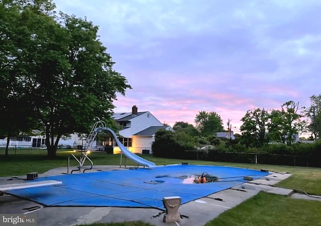307 Congress Dr, Gibbstown, NJ 08027 - pool at dusk featuring a diving board, a water slide, and a playground