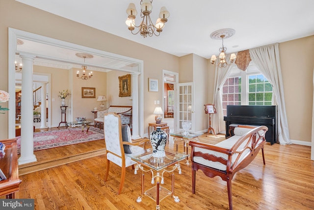sitting room featuring a chandelier, baseboards, and light wood-style floors