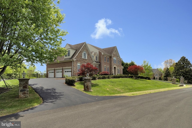 view of front of house featuring a garage, fence, a front yard, brick siding, and driveway