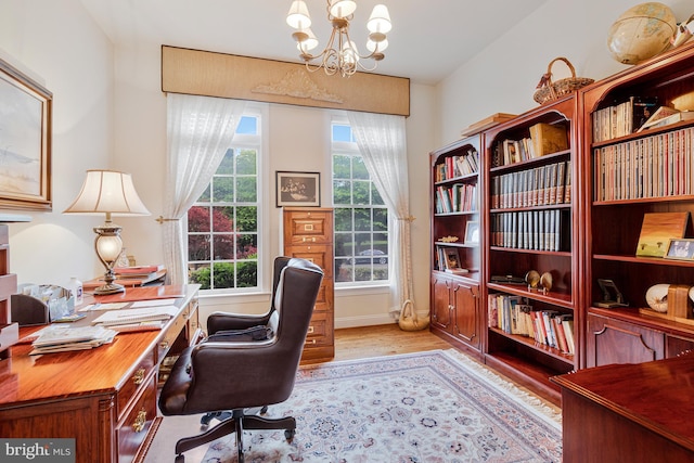 office featuring light wood finished floors and an inviting chandelier