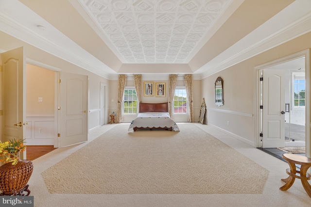 bedroom with carpet, baseboards, an ornate ceiling, and multiple windows