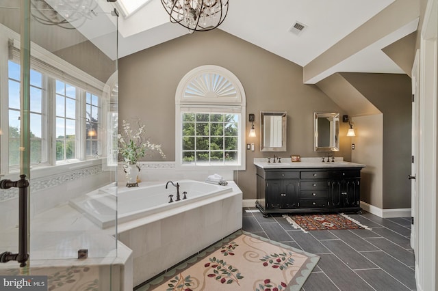 bathroom with a healthy amount of sunlight, lofted ceiling, a bath, and visible vents