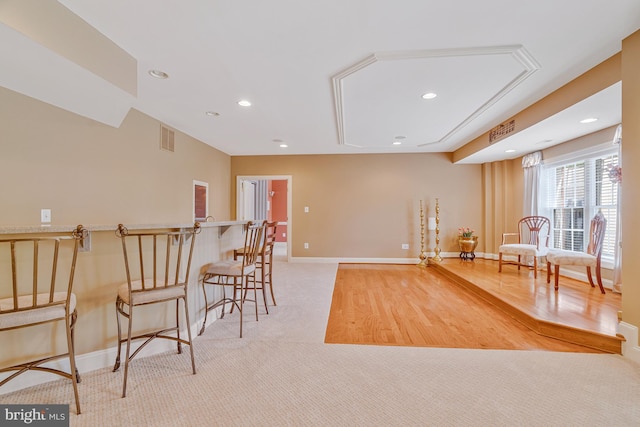 living area with light colored carpet, visible vents, baseboards, and recessed lighting