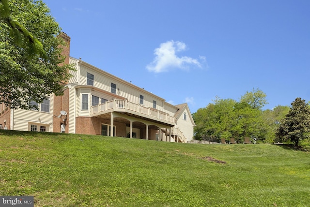 back of house featuring a lawn, a chimney, and a wooden deck