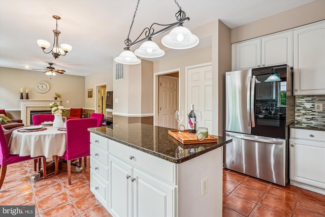 kitchen featuring light tile patterned flooring, tasteful backsplash, a center island, white cabinetry, and a chandelier