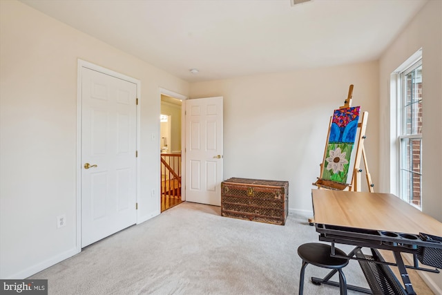 carpeted home office featuring baseboards